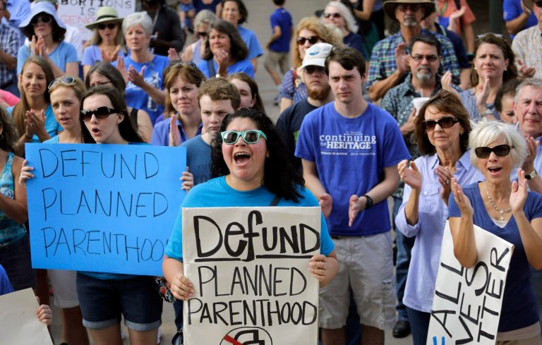 Erica Canaut, center, cheers as she and other anti-abortion activists rally on the steps of the Texas Capitol in Austin, Texas, to condemn the use in medical research of tissue samples obtained from aborted fetuses. Texas announced Monday, Oct. 19, 2015, that it was cutting off Medicaid funding to Planned Parenthood clinics following undercover videos of officials discussing fetal tissue, potentially triggering a legal fight like the one unfolding in neighboring Louisiana. (AP Photo/Eric Gay)