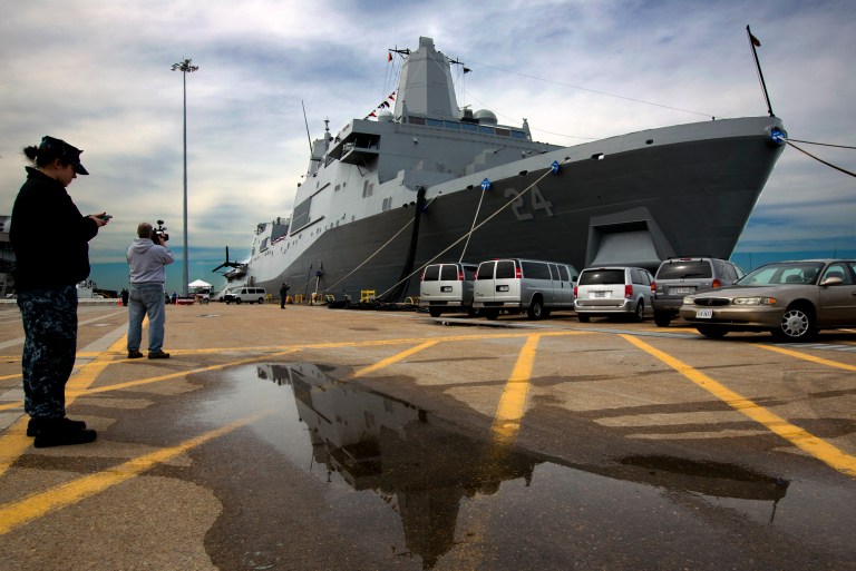In this April 5, 2013 photo, the USS Arlington sits dock in its new home port at Norfolk Naval Station in Norfolk, Va. The Navy commissioned the USS Arlington in front of about 5,000 people in its new home port of Naval Station Norfolk. The amphibious transport dock is one of three ships named after 9/11 crash sites, and 200 pounds of steel salvaged from the Pentagon's wreckage have been forged into a pentagon to be put on a permanent display aboard the ship in a memorial room. The ship also has 184 gold stars throughout the ship in honor of those who died when American Airlines Flight 77 crashed into the Pentagon on Sept. 11, 2011. (AP Photo/The Virginian-Pilot, The' N. Pham) MAGS OUT