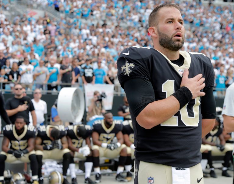 New Orleans Saints quarterback Chase Daniel (10) stands with his hand over his heart during the national anthem as other Saints players sit on the bench before an NFL football game against the Carolina Panthers in Charlotte, N.C., Sunday, Sept. 24, 2017. (AP Photo/Bob Leverone)