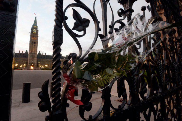 A rose rests in the main gate of Parliament Hill in Ottawa on Thursday. Cpl. Nathan Cirillo was killed Wednesday at the National War Memorial by a gunman who then raced to Parliament Hill, where he was killed in a gunfight in the halls of the Centre Block. (AP Photo/The Canadian Press, Adrian Wyld)