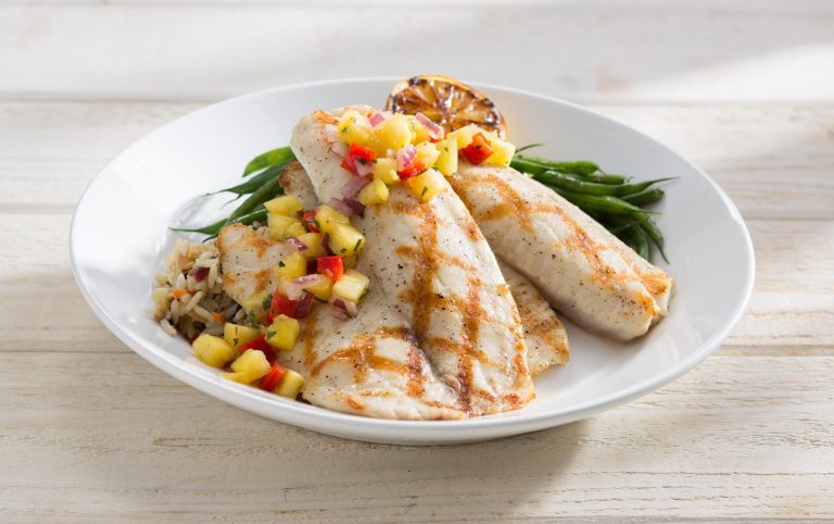This photo provided by Red Lobster shows its Wood Grilled Tilapia on a circular plate on which slabs of fish are piled over the rice, an architectural presentation that is common at higher-end restaurants. The new plating style marks the latest attempt by the struggling seafood to right its course as it embarks on a new era. (AP Photo/Red Lobster)