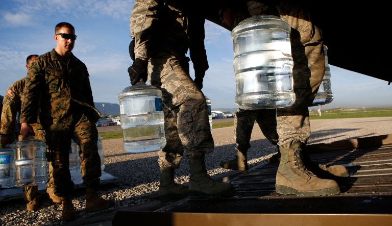 U.S. military troops load jugs of drinking water into a helicopter at the airport in Port-au-Prince Haiti, Friday, Oct. 14, 2016. A group of generals wrote a letter to President Trump encouraging him not to cut funding to diplomatic and humanitarian programs. (AP Photo/Rebecca Blackwell)
