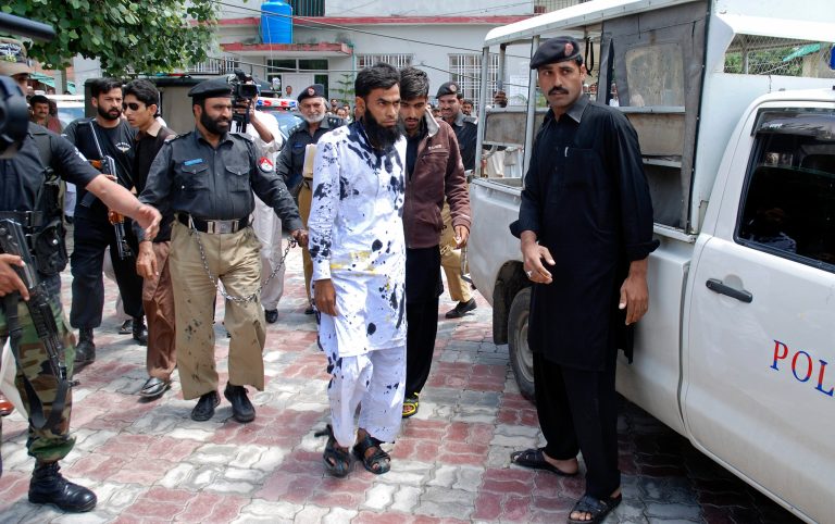 Pakistani suspects of a gang rape, center, leave a court after outraged citizens pelted the suspects with ink and tomatoes, in Mansehra, Pakistan, Wednesday, May 14, 2014. Pakistani police have arrested a seminary teacher and two of his friends on charges of gang raping a college girl in a city in the northwest, a police official said Wednesday. The case is unusual since rape cases are rarely prosecuted in Pakistan and women who complain are often stigmatized. (AP Photo/Aqeel Ahmad)