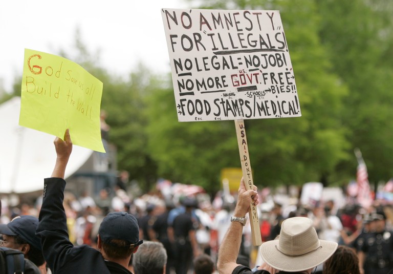 Anti-immigration demonstrators hold signs at an immigration rally in Dallas. (AP Photo/Mike Fuentes)