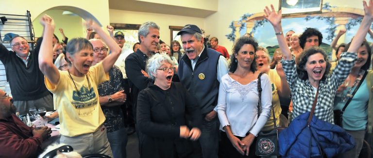 Measure 15-119 supporters react after learning that Roughly 66 percent of Jackson County voters favored banning GMO crops in the first round of election results released tonight while gathered at Capers Restaurant in Medford Ore. on May 20, 2014. ( AP Photo/Mail Tribune, Jamie Lusch)