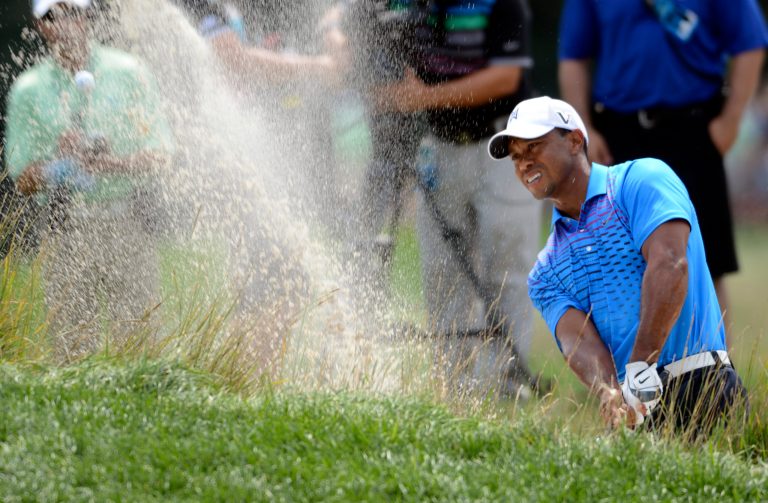 Tiger Woods blasts out of a sand trap on the second hole during the second round of The Barclays golf tournament at Bethpage State Park in Farmingdale, N.Y., Friday, Aug. 24, 2012. (AP Photos/Henny Ray Abrams)