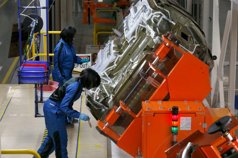 In this March 14, 2014 photo, assembly line workers build a 2015 Chrysler 200 automobile at the Sterling Heights Assembly Plant in Sterling Heights, Mich. The Commerce Department reports on the U.S. trade deficit for August on Friday, Oct. 3, 2014. (AP Photo/Paul Sancya)