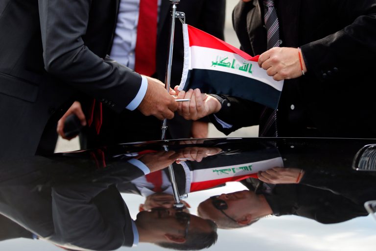 Officials install an Iraq flag on the car upon the arrival of Iraq President Fouad Massoum, and Iraq Foreign Minister Ibrahim Al-Jaafari at Orly airport south of Paris, France, Sunday, Sept. 14, 2014 ahead of a conference with U.S. Secretary of State John Kerry, French President Francois Hollande and diplomats from around the world. On Monday, Paris will host international talks seeking a strategy against the militants in Iraq, where they have overrun hundreds of miles of land in the country's north and west. (AP Photo/Francois Mori)