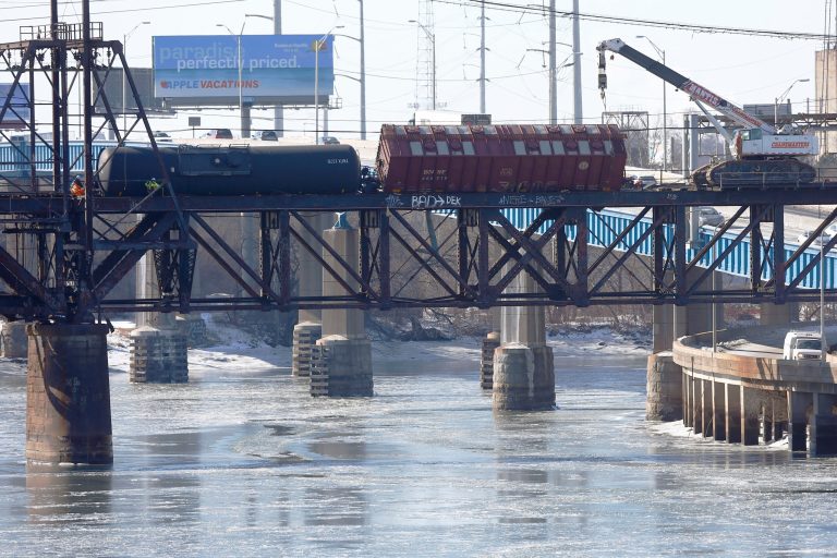 Railroad crews work on one of five derailed tank cars on a bridge in Philadelphia. The accident Monday follows a series of derailments involving Bakken Shale crude from North Dakota including one that exploded in Canada, killing 47 people. (AP Photo/Matt Rourke)