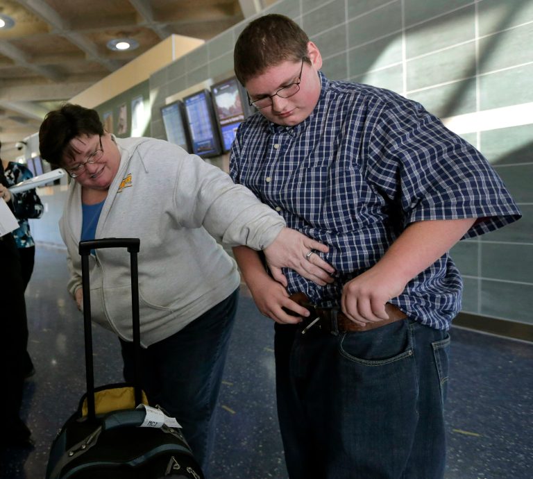   Debbie Alexander checks out her son Jason's baggy-fitting jeans after he returned from a four-month stay at a weight-loss boarding school Friday, Dec. 21, 2012, at the Kansas City International Airport in Kansas City, Mo. Alexander, nearly 100 pounds lighter, was among 14 students from the Independence, Mo., school district to attend the program, losing 756 pounds among themselves. (AP Photo/Charlie Riedel)  