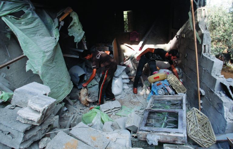 Palestinians look through their belongings in a house destroyed overnight by an Israeli airstrike in Beit Lahiya, northern Gaza Strip, Sunday, Nov. 11, 2012. Hostilities along the Gaza-Israel border escalated sharply over the weekend, with rocket salvos from Gaza and Israeli strikes killing at least six Palestinians. (AP Photo/Hatem Moussa)