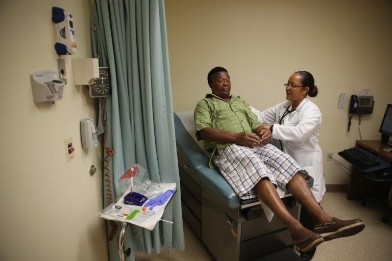 Felue Chang who is newly insured under an insurance plan through the Affordable Care Act receives a checkup from Dr. Peria Del Pino-White at the South Broward Community Health Services clinic on April 15, 2014 in Hollywood, Florida. (Photo by Joe Raedle/Getty Images