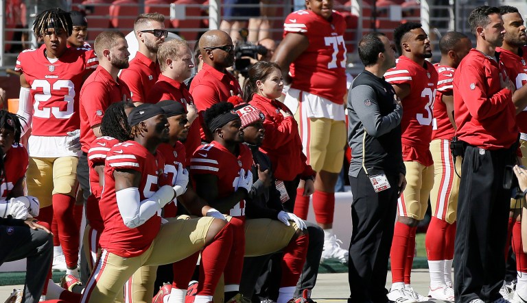 San Francisco 49ers players kneel during the performance of the national anthem before an NFL football game between the 49ers and the Dallas Cowboys. About two dozen NFL players protested during the national anthem on Sunday. (AP Photo/Eric Risberg)