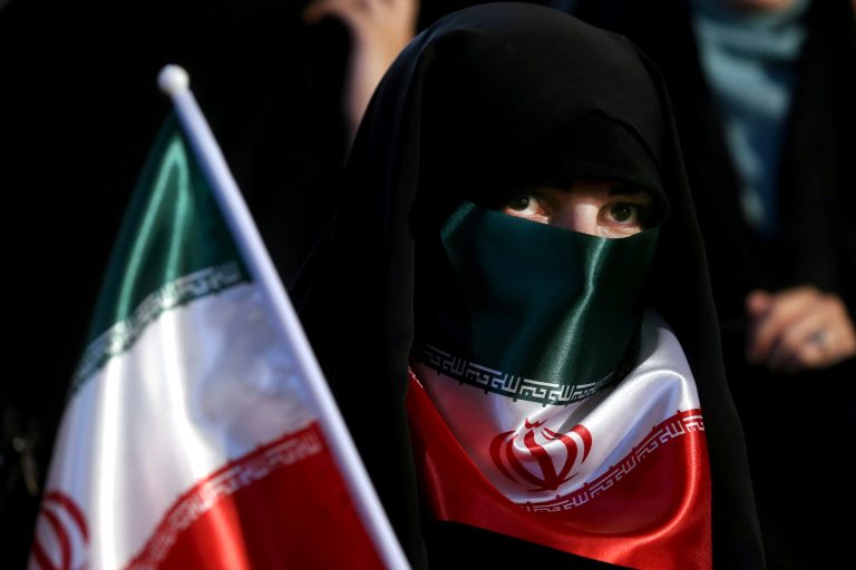 A female supporter of Iranian presidential candidate Ebrahim Raisi covers her face with Iran's flag during a campaign rally in Tehran on April 29. The majority of Iranians would prefer to do away with the entire repressive political system than choose between corrupt presidential candidates loyal to the supreme leader. (AP Photo/Ebrahim Noroozi)