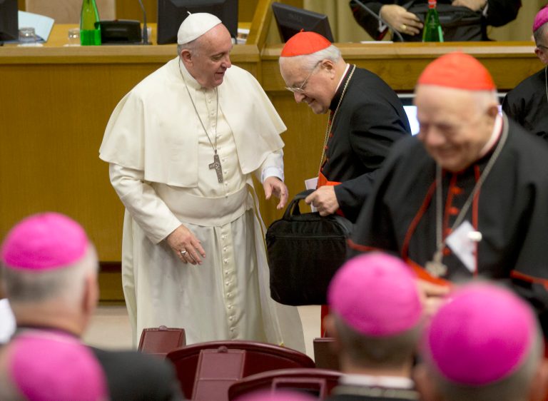 Pope Francis gives a bag to Cardinal Angelo Sodano as he arrives for the afternoon session of a two-week synod on family issues at the Vatican, Monday, Oct. 6, 2014. Francis has urged bishops to speak their minds about contentious issues like contraception, gays, marriage and divorce at the start of the meeting aimed at making the church's teaching on family matters relevant to today's Catholics. (AP Photo/Alessandra Tarantino)