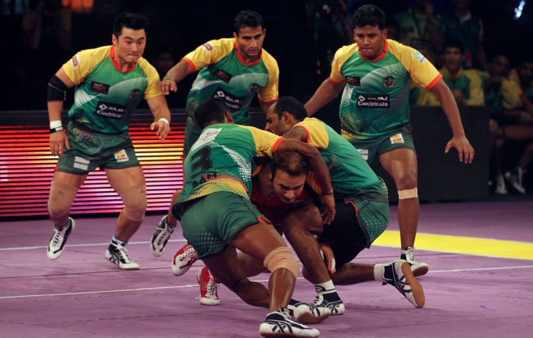 ADVANCE TO GO WITH STORY SLUUGED 'INDIA KABADDI MADNESS' BY PATRICK REEVELL- In this Sunday, Aug. 31, 2014 photo, players of  Patna Pirates try to grab a  Bengaluru Bulls player during a the Pro Kabaddi League in Mumbai, India. A favorite kidsâ game, largely forgotten in adulthood, the launch of the Pro-Kabaddi League in July has catapulted kabaddi back into the Indian national consciousness, injected with serious money and Bollywood glamour. The twelve teams touring five cities across India attracted sell-out crowds and 22 million tuned in to the semi-finals. (AP Photo/Rafiq Maqbool)