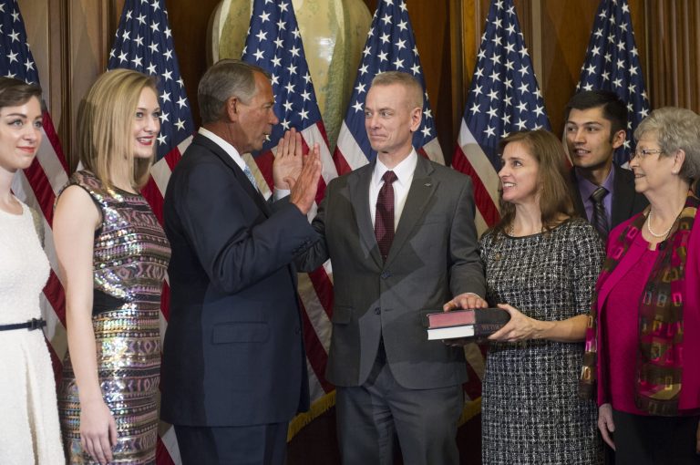 House Speaker John Boehner of Ohio administers a ceremonial re-enactment of the House oath-of-office to Rep. Steve Russell R-Okla. accompanied by his wife Cindy and family, Tuesday, Jan. 6, 2015, on Capitol Hill in Washington. (AP Photo/Cliff Owen)