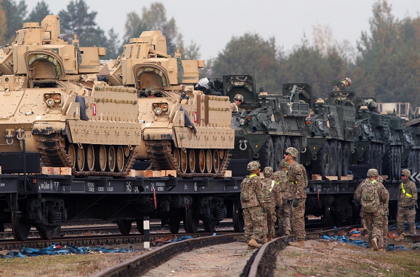 Members of the US Army 1st Brigade, 1st Cavalry Division, transport heavy combat equipment including Bradley Fighting Vehicles and Stryker Armored Vehicles at the railway station near the Rukla military base in Lithuania, on October 4, 2014. (PETRAS MALUKAS/AFP/Getty Ima