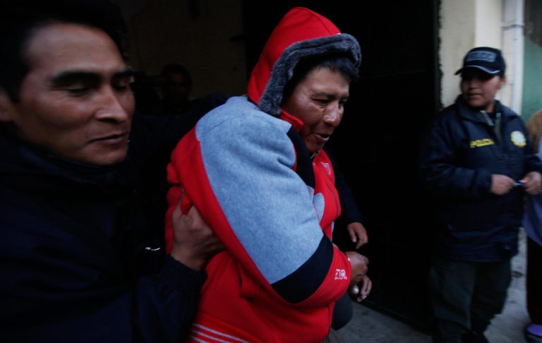 Javier Cusi Aduviri, center, is escorted by Bolivian police officers at the police station in El Alto, Bolivia, Thursday, June 26, 2014. An emotionally disturbed Cusi Aduviri wielding a kitchen knife went on a rampage in the terminal of the La Paz international airport on Thursday, stabbing 11 people, authorities said. Deputy Interior Minister Jorge Perez said the attacker told police he 