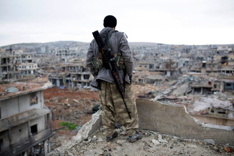 In this Jan. 30, 2015 file photo, a Syrian Kurdish sniper looks at the rubble in the Syrian city of Ain al-Arab, also known as Kobani. (AP Photo, File)