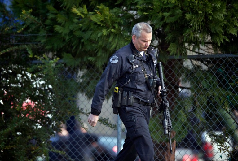 Police secure the scene of a shooting at a business park in the Fruit Valley neighborhood of Vancouver, Wash. on Monday Feb. 3, 2014. Police say at least one person was shot just before noon Monday at a Benjamin Moore Paint store in the area. (AP Photo/The Columbian, Zachary Kaufma)