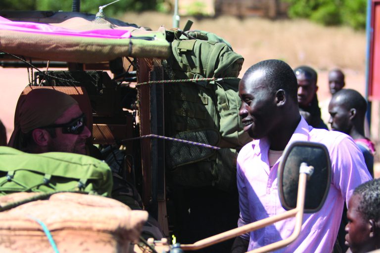 A resident of San in central Mali talks with a French soldier in his vehicle as French troops pass through en route to Sevare, Mali, Friday, Jan. 18, 2013. French forces encircled a key Malian town on Friday to stop radical Islamists from striking closer to the capital, a French official said. The move to surround Diabaly came as French and Malian authorities said they had retaken Konna, the central city whose capture prompted the French military intervention last week.(AP Photo/Harouna Traore)