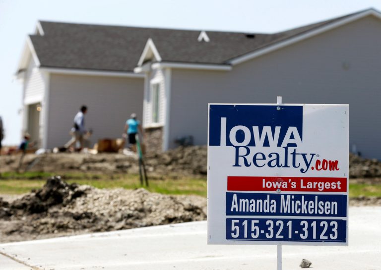 In this May 21, 2014 photo, a sign sits in front of a home for sale in West Des Moines, Iowa. The Commerce Department releases new home sales for May on Tuesday, June 24, 2014. (AP Photo/Charlie Neibergall)