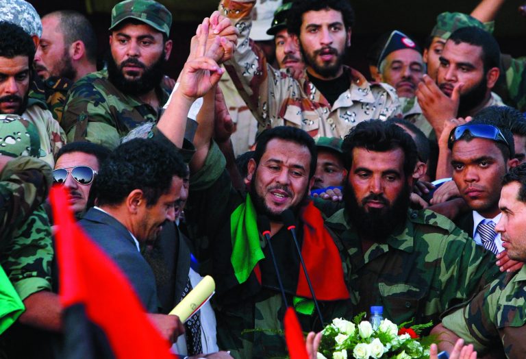 FILE - In this Sunday, Oct. 23, 2011 file photo, Libyan National Transitional Council military commander of Tripoli Abdel Hakim Belhaj waves prior to his speech at Saha Kish Square in Benghazi, Libya, as Libya's transitional government declare liberation of Libya after months of bloodshed that culminated in the death of longtime leader Moammar Gadhafi. Libya's elections bring in a large new political generation of independents _ businessmen, activists, former judges and former exiles _ who form the largest bloc in the first elected national assembly after Moammar Ghadafi's fall and will be the big wild card in determining the country's course. Both a coalition led by secular former Prime Minister Mahmoud Jibril and Islamists led by the Muslim Brotherhood are trying to woo them, but many of the independents are trying to form their own coalition, distrusting both sides.(AP Photo/Francois Mori, File)