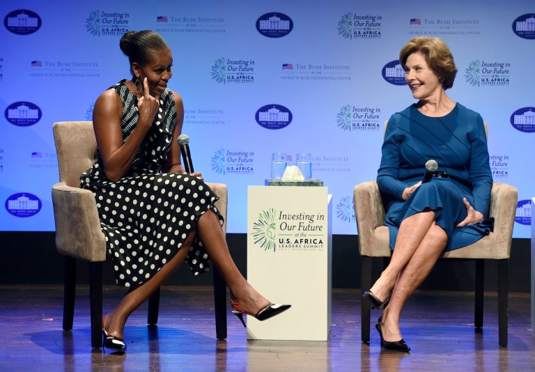 First lady Michelle Obama, left, points out her hairstyle as she sits with former first lady Laura Bush as they participate in the 