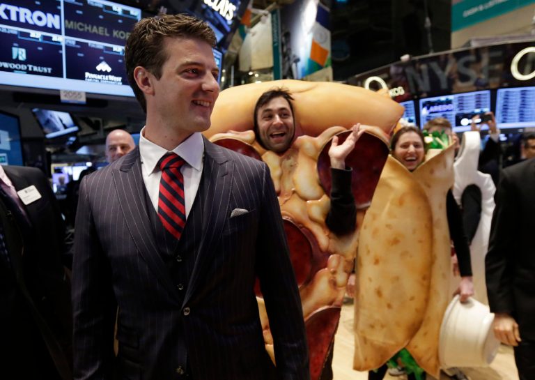 GrubHub CEO Matthew Maloney, trailed by costume characters, walks the New York Stock Exchange trading floor before his company's IPO begins trading, Friday, April 4, 2014. Investors sent shares of online food ordering service GrubHub Inc. up 51 percent to $39.20 in early trading in its stock market debut Friday. (AP Photo/Richard Drew)