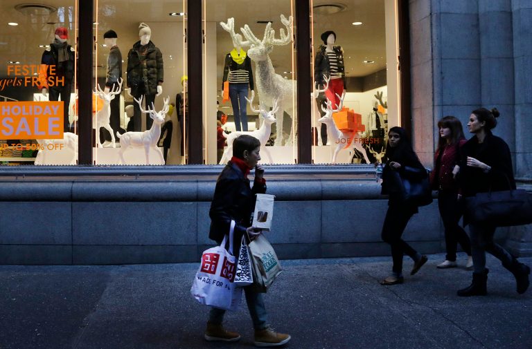 In this Friday, Nov. 22, 2013 photo, shoppers walk past windows at a Joe Fresh clothing store in New York. U.S. consumer confidence jumped in December 2013 on a better outlook for hiring and growth, supporting other signs that show the economy could accelerate in 2014. (AP Photo/Mark Lennihan)
