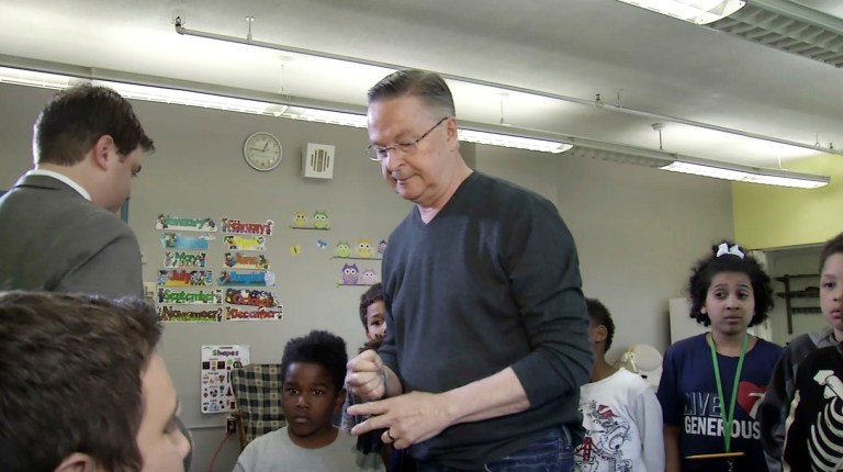 U.S. Rep. Rod Blum, center, walks out of a televised interview with Josh Scheinblum in front of a group of schoolchildren in Dubuque, Iowa, when pressed about screening attendees to his public meetings. (KCRG via AP)