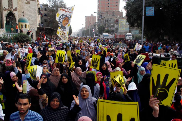 Supporters of ousted President Mohammed Morsi show their symbolic sign of four fingers to commemorate the protesters killed and injured during the Aug. 14 dispersal while marching on a street in Cairo, Egypt, Friday, Feb. 14, 2014. Morsi supporters had camped out in two locations in Cairo for nearly two months before police moved in to break up the sit-in encampments on Aug. 14 last year, killing at least 600. (AP Photo/El Shorouk newspaper, Ahmed Abdel Fattah) EGYPT OUT