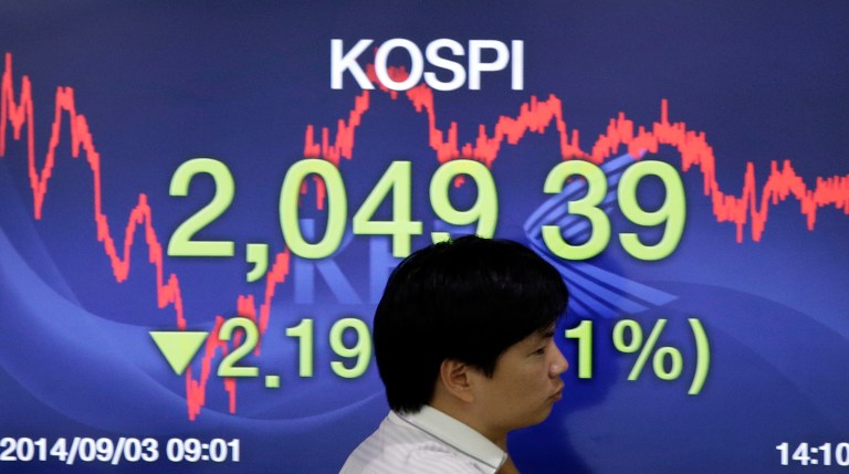 A currency trader walks by a screen showing the Korea Composite Stock Price Index (KOSPI) at the foreign exchange dealing room of the Korea Exchange Bank headquarters in Seoul, South Korea, Wednesday, Sept. 3, 2014. Asian stock markets rose Wednesday, lifted by new signs of strength in the U.S. economy and expectations that Europe's central bank will provide more support to the flagging region. (AP Photo/Lee Jin-man)