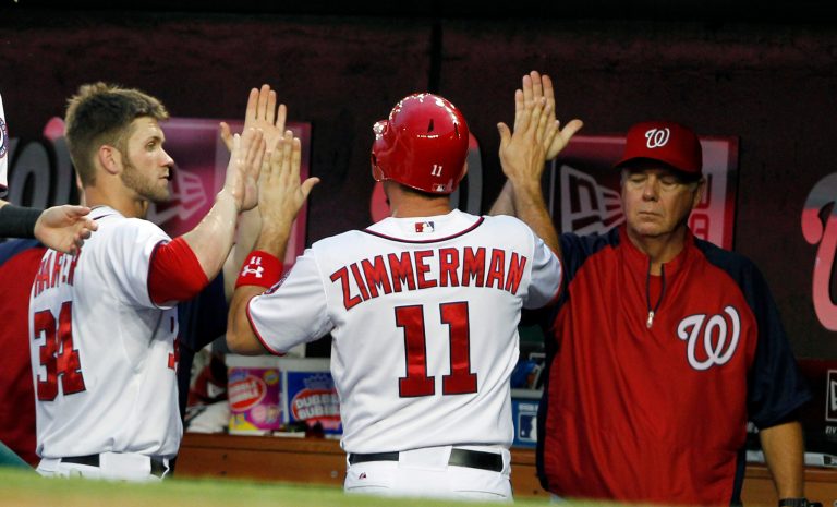 Washington Nationals' Ryan Zimmerman (11) celebrates with Bryce Harper (34) and pitching coach Steve McCatty, right, after scoring during the fourth inning of a baseball game with the San Francisco Giants, Tuesday, July 3, 2012, in Washington. (AP Photo/Alex Brandon)