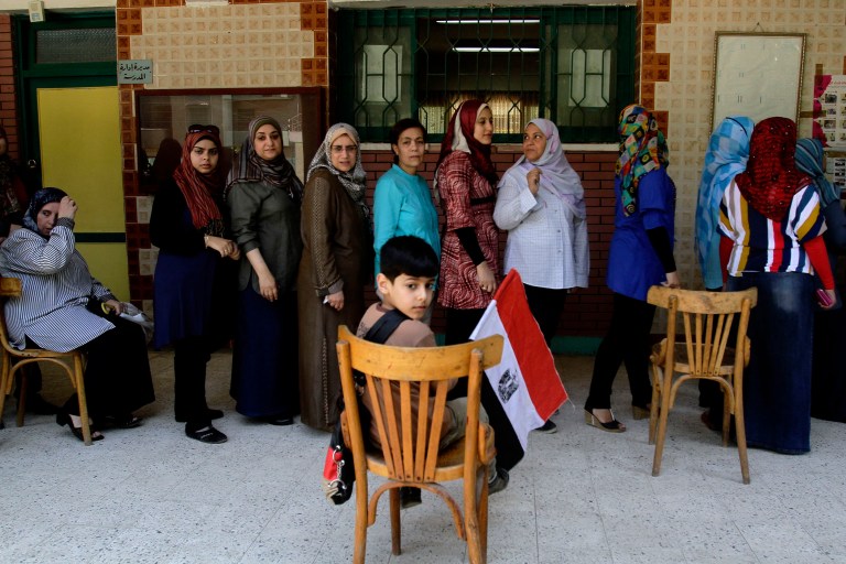 Egyptian women wait in line before casting their ballots at a polling station in a presidential election that comes nearly a year after the military's ouster of the nation's first freely elected president, the Islamist Mohammed Morsi, in Zagazig, 63 miles (100 kilometers) northeast of Cairo, Egypt, Monday, May 26, 2014. Abdel-Fattah el-Sissi's supporters danced to pop tunes praising the military and sported T-shirts bearing his image as they cast ballots Monday in a presidential election that is seen certain to vault the retired field marshal to office. (AP Photo/Ahmed Sayed)