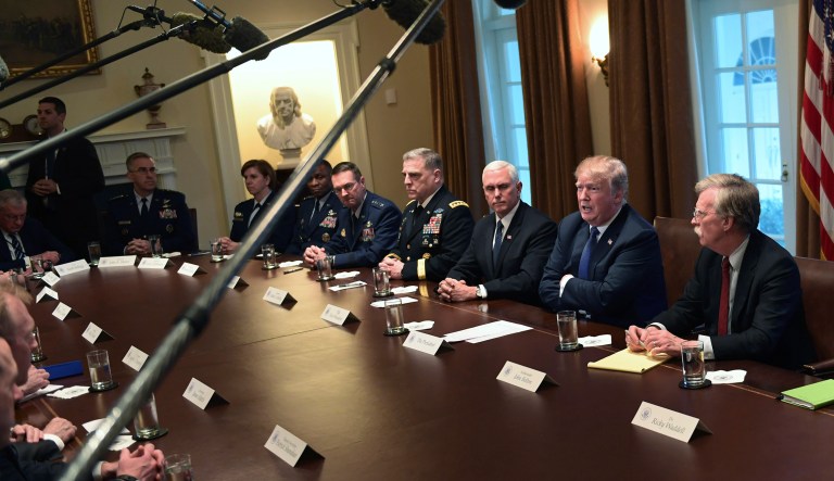 President Donald Trump, second from right, speaks in the Cabinet Room of the White House in Washington, Monday, April 9, 2018, at the start of a meeting with military leaders. Trump is flanked by Vice President Mike Pence, left, and national security adviser John Bolton, right.