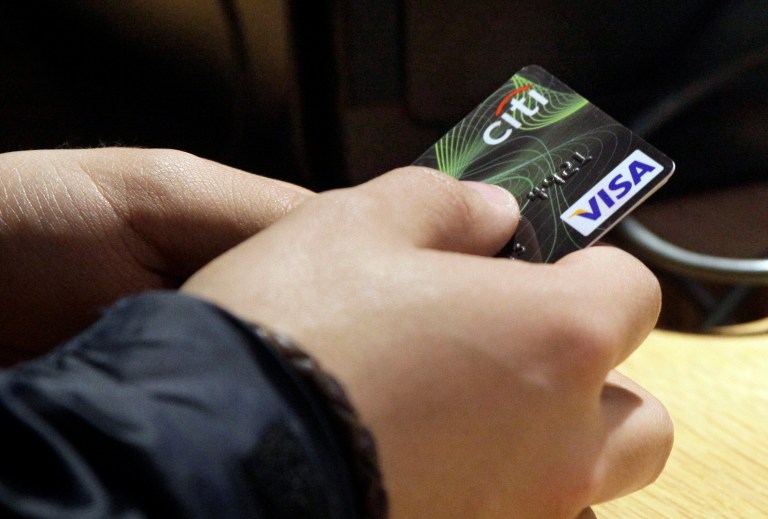 FILE - In this May 9, 2012 file photo, a Visa credit card is offered at the opening of the Superdry store in New York's Times Square. The Federal Reserve releases consumer credit data for August on Tuesday, Oct. 7, 2014. (AP Photo/Richard Drew, File)