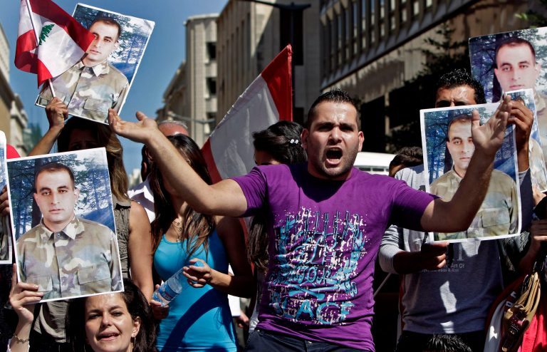 Families of missing soldiers who were kidnapped by Islamic State militants and the Al-Nusra front, chant slogans as they hold portraits of Lebanese soldier Saif Thebian, during a demonstration to demand action to secure the captives release, in front the Lebanese government building, in downtown Beirut, Lebanon, Thursday, Oct. 2, 2014. Militants, including from the Islamic State extremist group, seized around 30 soldiers and policemen after overrunning a Lebanese border town in early August. (AP Photo/Bilal Hussein)