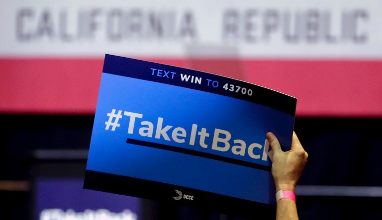 In this Thursday, Oct. 4, 2018, photo a supporter holds up a sign for Gil Cisneros, a candidate who is running for a U.S. House seat in the 39th District in California, at a rally on the Cal State Fullerton campus in Fullerton, Calif. For decades, Orange County, California, was known as a Republican stronghold but times have changed.