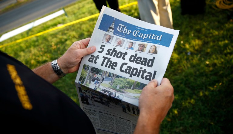 Steve Schuh, county executive of Anne Arundel County, holds a copy of The Capital Gazette near the scene of a shooting at the newspaper's office, Friday, June 29, 2018, in Annapolis, Md. A man armed with smoke grenades and a shotgun attacked journalists in the building Thursday, killing several people before police quickly stormed the building and arrested him, police and witnesses said.