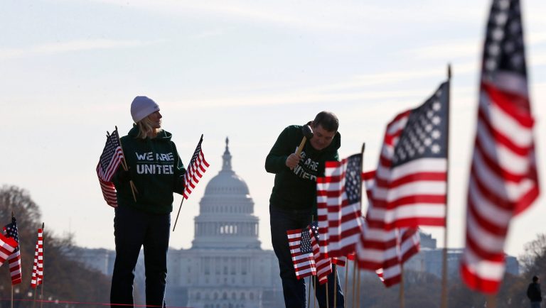 With the Capitol in the background, Army veteran David Dickerson of Oklahoma City, Okla., right, and Air Force veteran Linda Stanley, from San Diego, Calif., now with Iraq and Afghanistan Veterans of America (IAVA), join others to place 1,892 flags representing veteran and service members who have died by suicide to date in 2014, Thursday, March 27, 2014, on the National Mall in Washington. The event also marked the introduction of The Suicide Prevention for America's Veterans Act by Sen. John Walsh, D-Mont., which calls for greater access to mental health care. 