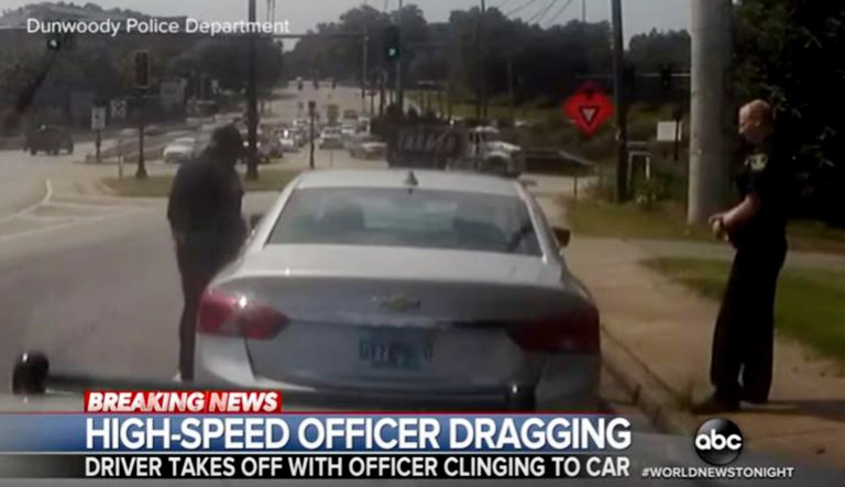 Two police officers are seen at a traffic stop.