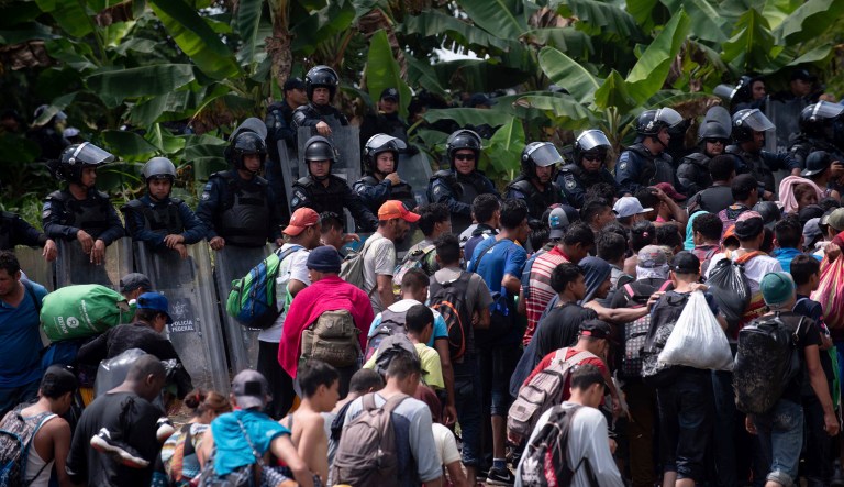 A new group of Central American migrants walk past Mexican Federal Police after the migrants waded in mass across the Suchiate River, that connects Guatemala and Mexico, in Tecun Uman, Guatemala, Monday, Oct. 29, 2018.