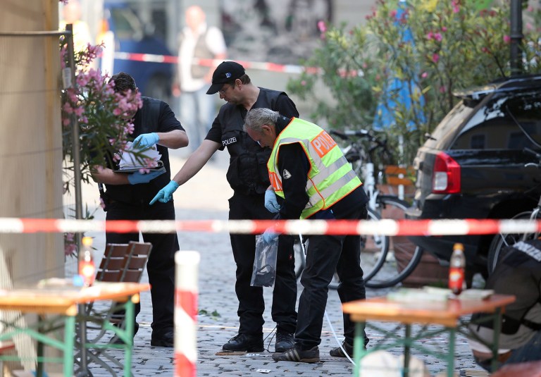 German police investigates at the site in Ansbach, Germany, where a failed asylum-seeker from Syria blew himself up and wounded 15 people. The man recorded a cell phone video of himself pledging allegiance to the Islamic State group before he tried to get into the outdoor concert with a bomb-laden backpack. (Daniel Karmann/dpa via AP)