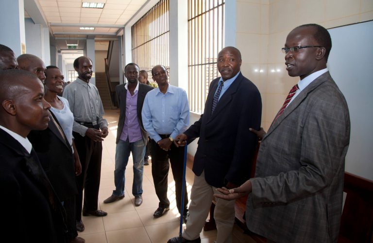 FILE - In this Friday, Oct. 18, 2013 file photo, Kenyan journalist Walter Barasa, right, speaks to supporters before attending a court hearing to determine whether authorities will enforce an International Criminal Court (ICC) arrest warrant against him, at the Milimani court in Nairobi, Kenya. A Kenyan court Friday, Jan. 31, 2014 refused to stop the arrest of Barasa who is wanted by the ICC for allegedly interfering with prosecution witnesses in the crimes against humanity case against Kenya's Deputy President William Ruto. (AP Photo/Sayyid Azim, File)