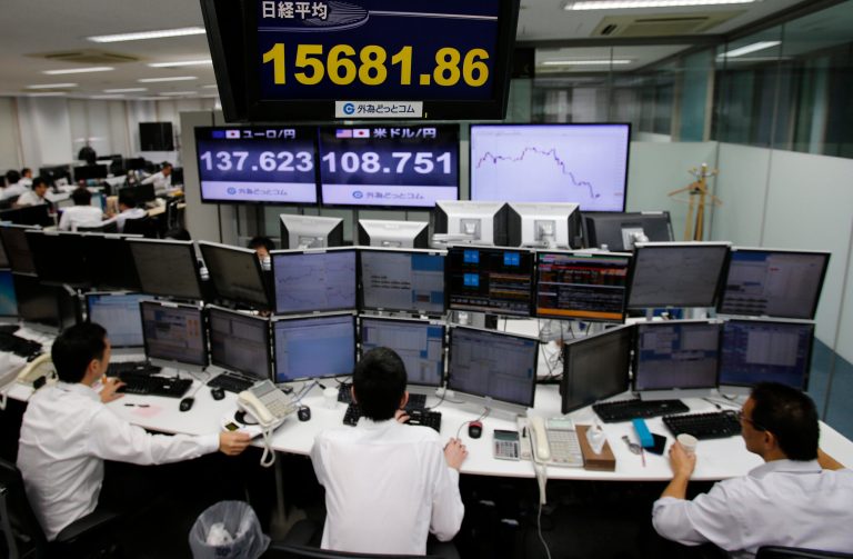 Employees at a foreign exchange brokerage sit at a computer terminal under electric boards flashing the current figures of Japanese yen against dollar and stock market in Tokyo, Thursday, Oct. 2, 2014. Asian stocks fell Thursday amid worries about the strength of U.S. and European recoveries and the first American case of Ebola. Japan's Nikkei 225 index lost 1.7 percent to 15,815.45 points. (AP Photo/Shuji Kajiyama)