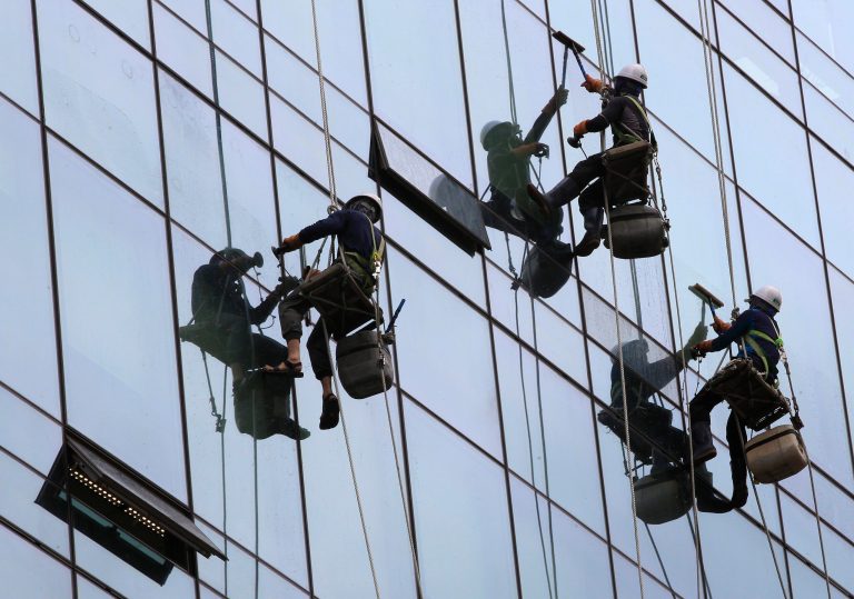 Workers clean windows of a building in Seoul, South Korea, Thursday, June 5, 2014. South Korea's economic growth hit its highest level in three years in the first quarter, boosted by new home construction and exports of electronics.  (AP Photo/Ahn Young-joon)