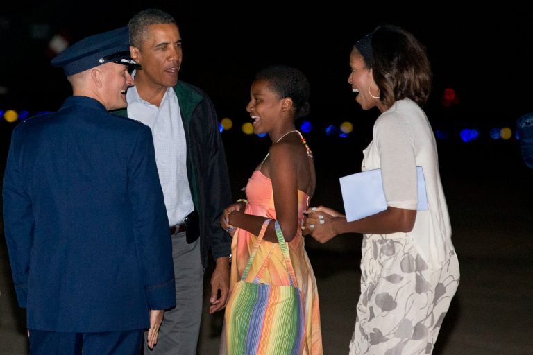   President Barack Obama, second from left, Sasha Obama, and first lady Michelle Obama, are greeted as they exit Air Force One on arrival at Andrews Air Force Base, Md., on Sunday Aug. 18, 2013, after a family vacation on the island of Martha's Vineyard. Also with them was Malia Obama, not pictured. (AP Photo/Jacquelyn Martin)  