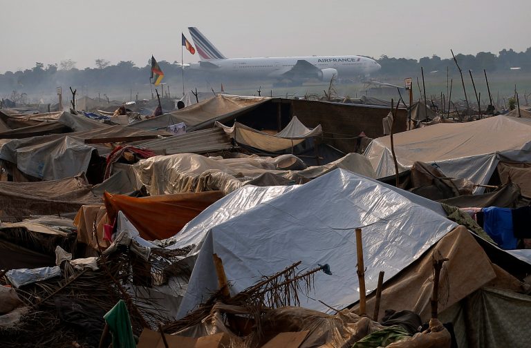An Air-France plane taxis past a refugee camp outside the airport in Bangui, Central African Republic, Tuesday Jan. 28, 2014.  Christian refugees are living in makeshift shelters near the airport in Bangui, as they try to escape from the deepening divisions between the country's Muslim minority and Christian majority.  Christian refugees who have fled sectarian violence complain about the lack of aid reaching their impoverished tent city. (AP Photo/Jerome Delay)